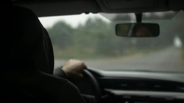 Shot of the men driving a car in countryside.