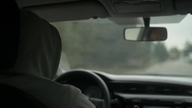 Shot of the men driving a car in countryside.