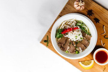 Traditional oriental cuisine of  Vietnam. Pho bo soup with rice noodles, beef, pepper, wheat germ, greens