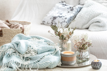 Home decorations in the interior. A turquoise blanket and wicker basket with a vase of flowers and...