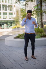 Fototapeta premium Successful young businessman talking on his smartphone outside