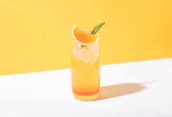 Fotobehang Cold and refreshing orange punch cocktail with orange slice on yellow background. summer drink. © NaMong Productions