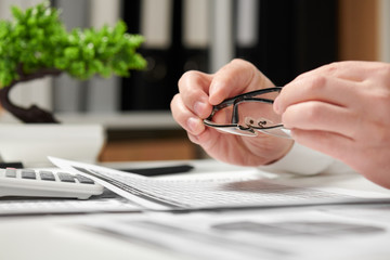 Businessman working in office and calculating finance. He takes glasses. Business financial...