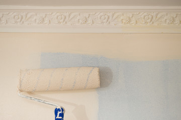 Person applying paint on wall