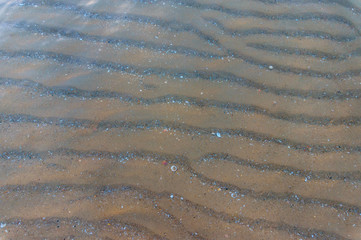 Fototapeta na wymiar sandy bottom in the crystal clear sea water. Background. Texture of the seabed on a Sunny day