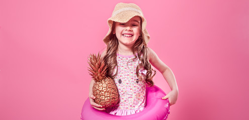Obraz na płótnie Canvas happy child with pineapples on a colored background