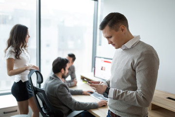 Fototapeta premium Portrait of businessman using phone in office