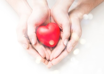 Man and woman holding red heart in hands isolated