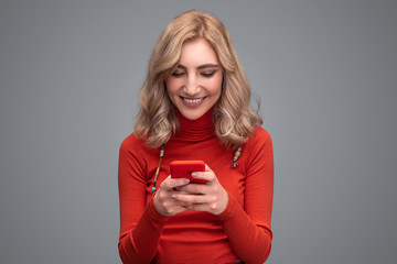 Smiling lady browsing smartphone