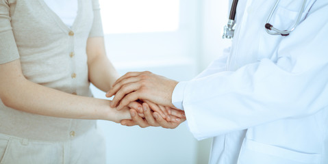Obraz premium Hand of doctor reassuring her female patient. Medicine and health care concept