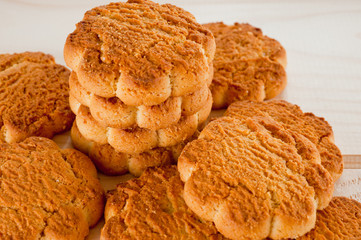 Tasty and beautiful cornflakes cookies among of corn flakes on a wooden table as background, top view