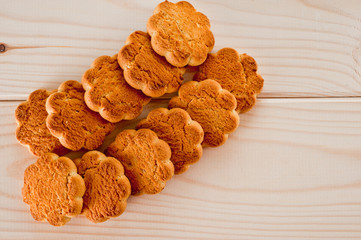 Tasty and beautiful cornflakes cookies among of corn flakes on a wooden table as background, top view