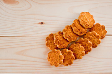 Tasty and beautiful cornflakes cookies among of corn flakes on a wooden table as background, top view