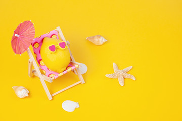 Lemon in sunglasses in the sunbed with umbrela at the beach