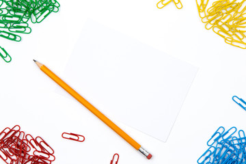 Pencil, paper clips lie in different angles of the sheet on a white background. Hero image and copy...