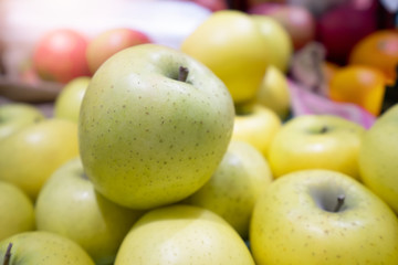 Green apple pile on shelf at supermarket