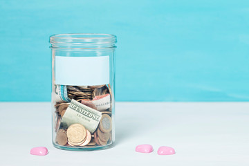 Coins and banknotes in glass money jar, financial donations, charity concept