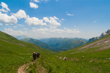 Fototapeta na wymiar A few of tourists walking along the trail in the mountains.