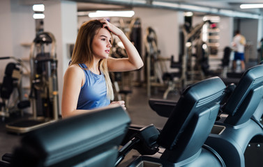 Fototapeta na wymiar A portrait of young girl or woman doing cardio workout in a gym.