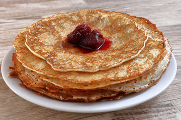 Juicy ruddy hot flavored pancakes with strawberry jam - an amazing dessert.