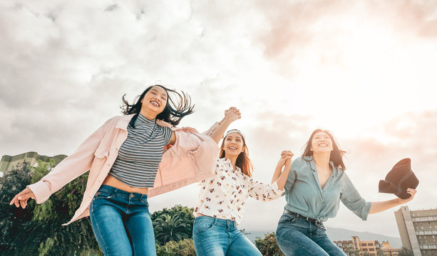 Happy Asian girls jumping outdoor - Young women friends having fun during university break - Millennial generation, friendship and youth people lifestyle