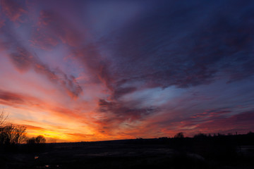 Natural Sunset of sun over field or meadow. Earth in the shadow of a colorful sky