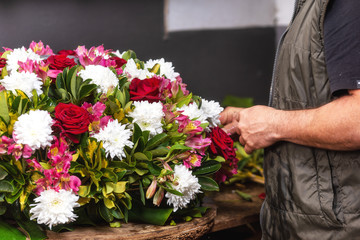 Florist at work. Male florist creating beautiful bouquet at flower shop. Close up.