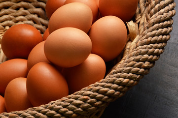 Stack of brown eggs in a wicker basket