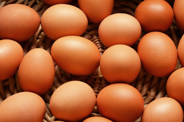 Brown eggs on a wicker basket background