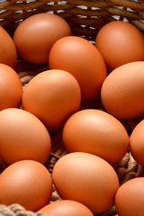 Brown eggs on a wicker basket background