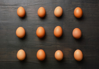 Group of eggs in a row on the black wood background