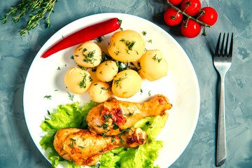 Chicken legs with potatoes and vegetables.