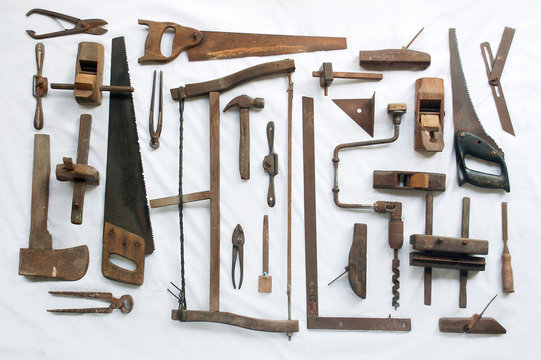Collection of antique woodworking tools on white cloth