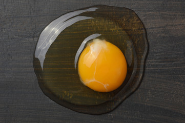 Raw egg yolk on black wood board