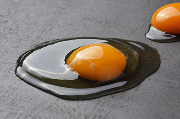 Raw egg yolk on black wood board