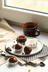Chocolate Cake Pops with Prunes, Walnuts and Smoked Paprika, served in paper cups on plate, on light background.