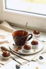 Chocolate Cake Pops with Prunes, Walnuts and Smoked Paprika, served in paper cups on plate, on light background.