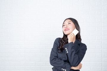 Business woman holding a separate cash card, white brick wall Made gestures with sign language.