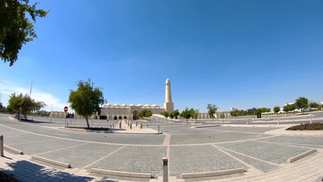 Walkway towards State Grand Mosque and minaret in a sunny day with blue sky in Doha Downtown, Middle East, Arabian Peninsula, Persian Gulf. Famous landmark in Doha West Bay.