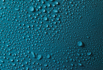 Drops of water on a blue glass texture background