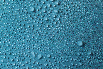 Drops of water on a blue glass texture background