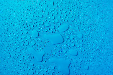 Drops of water on a blue glass texture background