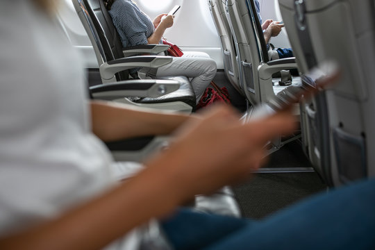 Passangers in abord a commercial flight using their cell phones during flight
