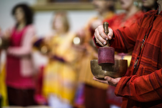 Man playing on a tibetian singing bowl (shallow DOF; color toned image)