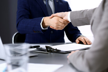 Business people shaking hands, finishing up a meeting. Papers signing, agreement and lawyer consulting concept