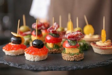 Tasty canapes on slate plate, closeup