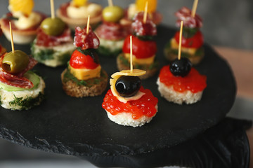 Tasty canapes on slate plate, closeup