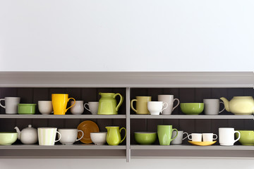 Shelves with clean dishes on white background