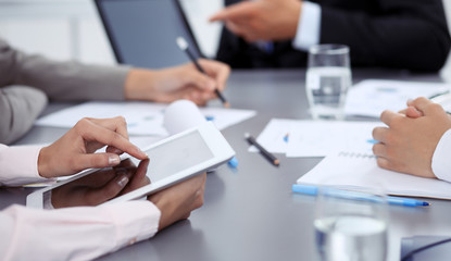 Woman hands using tablet at meeting. Business people group working together in office, close-up. Negotiation and communication concept