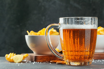 Lager beer and snacks on stone table. Cracker, chips side view